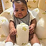 adorable, baby, baby_girl, child, chubby_cheeks, clothing, container, cute, hair_buns, hair_clips, indoor, infant, inflatable_chair, person, plush, seat, smiling, teddy_bear, toddler, white_socks