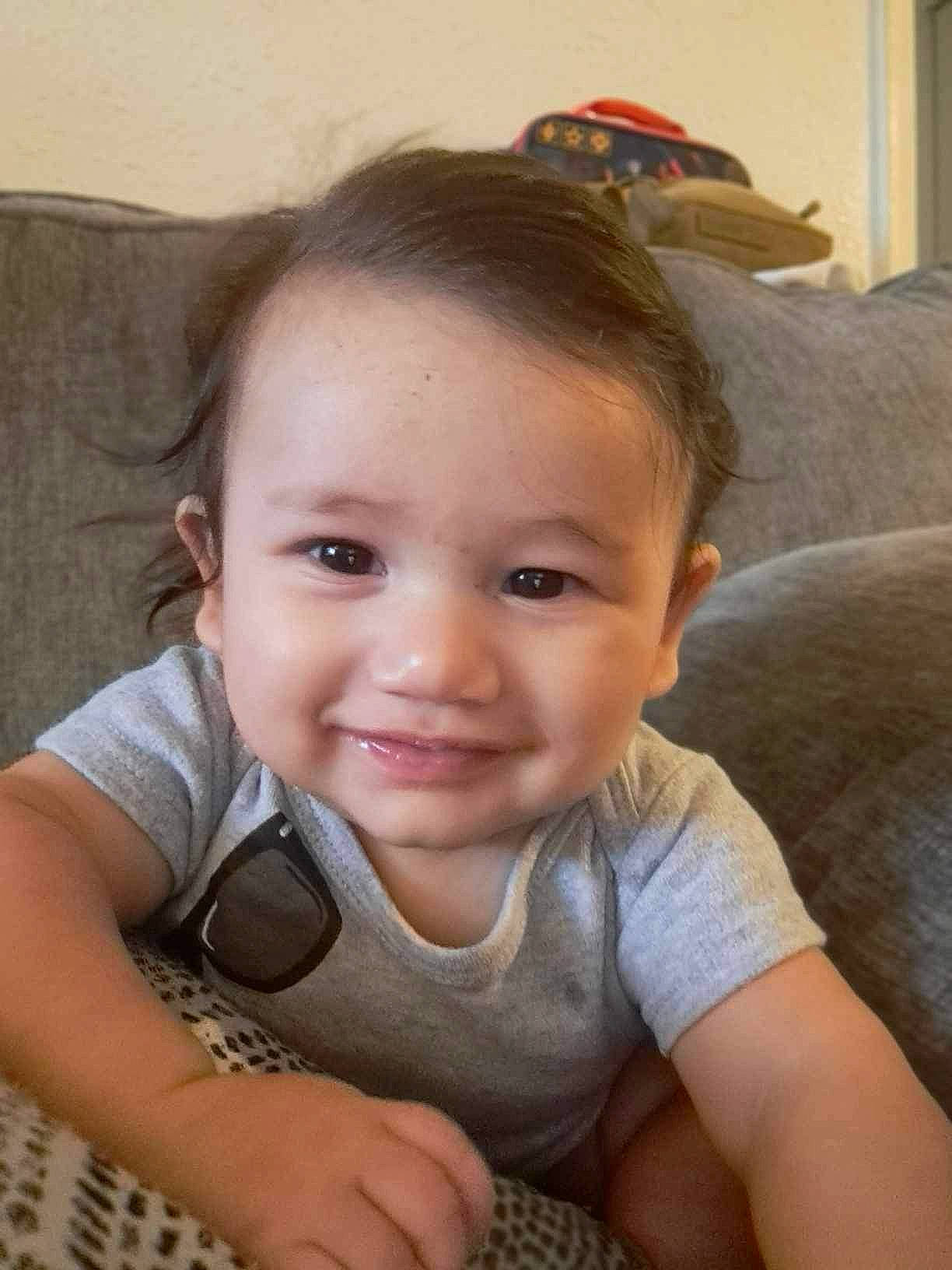 Elijah is registered to the contest to win money with this photo: arm, baby, baby_toddler_clothing, cheek, comfort, eye, facial_expression, finger, flash_photography, floor, flooring, hand, happy, iris, joy, lip, mouth, nose, person, skin