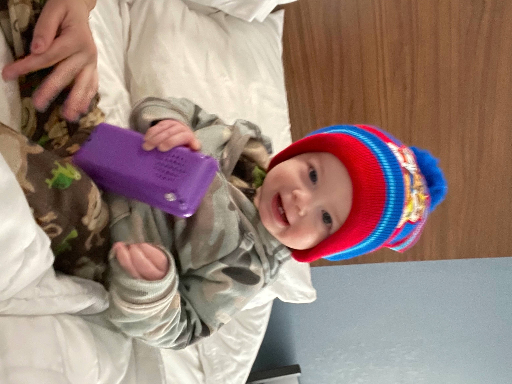 Leonidas is registered to the contest to win money with this photo: baby, baby_products, baby_toddler_clothing, baseball_cap, beanie, cap, child, comfort, event, fashion_accessory, fun, happy, hat, headwear, person, play, purple, room, smile, sun_hat