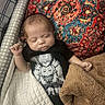 baby, infant, sleeping, portrait, indoors, blanket, bedding, rug, carpet, black_shirt, anime_shirt, patterned_background, cozy, peaceful, resting, closed_eyes, hands, arms, textile, photography
