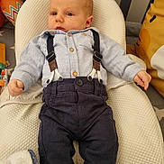 Martin participe au concours pour gagner de l'argent avec cette photo : baby, infant, clothing, suspenders, pants, shirt, blanket, cushion, pillow, indoor, person, child, cute, lying_down, comfortable, soft_texture, home, resting, young, fashion