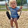 Lillian is registered to the contest to win money with this photo: child, toddler, swing, playground, outdoor, summer, curly_hair, blue_romper, sandals, holding_chains, daylight, trees, grass, wood_chips, park, cute, young, person, happy, playing