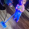 Lillian is registered to the contest to win money with this photo: toddler, child, pajamas, mop, floor, wooden_floor, indoor, toy, footwear, slippers, person, cleaning, looking_up, lighting, home, young_child, curious, standing, blue_light, flooring