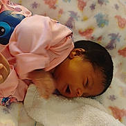 Ernlyiana joined the competition — help win amazing prizes! baby, newborn, infant, pink_clothing, blanket, floral_pattern, sleeping, hand, face, person, cute, resting, soft, indoors, child, young, skin, head, dark_hair, cozy