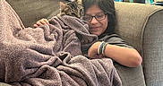 Beans joined the competition — help win amazing prizes! blanket, bracelets, carpet, cat, child, couch, cozy, cup, folded_clothes, framed_photo, girl, glasses, kitten, lamp, living_room, pet, snuggling, sofa, throw_blanket, towel_stripes