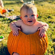 Haisten is registered to the contest to win money with this photo: baby, pumpkin, grass, outdoor, child, smiling, cute, sunlight, pigtails, fall, nature, playful, happy, barefoot, seasonal, person, holiday, fun, carving, daytime