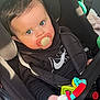 baby, black_hoodie, car_interior, car_seat, child, child_safety, close_up, curious, cute, holding_toy, indoor, infant, nike_logo, pacifier, portrait, seatbelt, secure, sunlight, toy, wide_eyes
