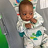 Wave joined the competition — help win amazing prizes! baby, baby_chair, child, clothing, colorful, comfort, curious, cute, dinosaur, expression, face, head, indoor, infant, looking_away, onesie, patterned, playful, seated, small_hands