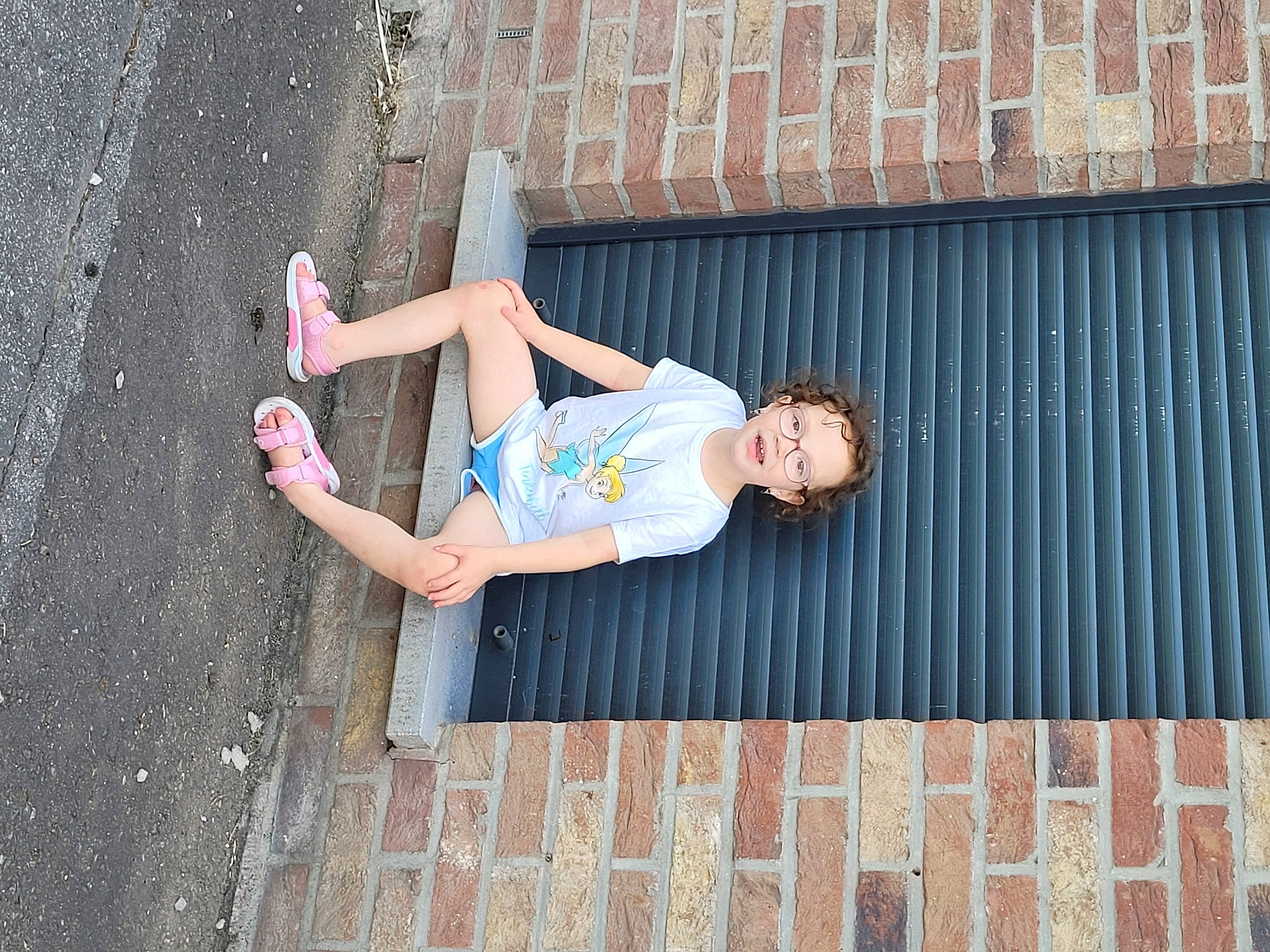 Amélie a rejoint le concours — aidez-le/la à gagner de superbes lots ! asphalt, beauty, brick, brickwork, child, concrete, electric_blue, facade, flash_photography, fun, happy, human_leg, leisure, person, recreation, shorts, sitting, street, thigh, tree