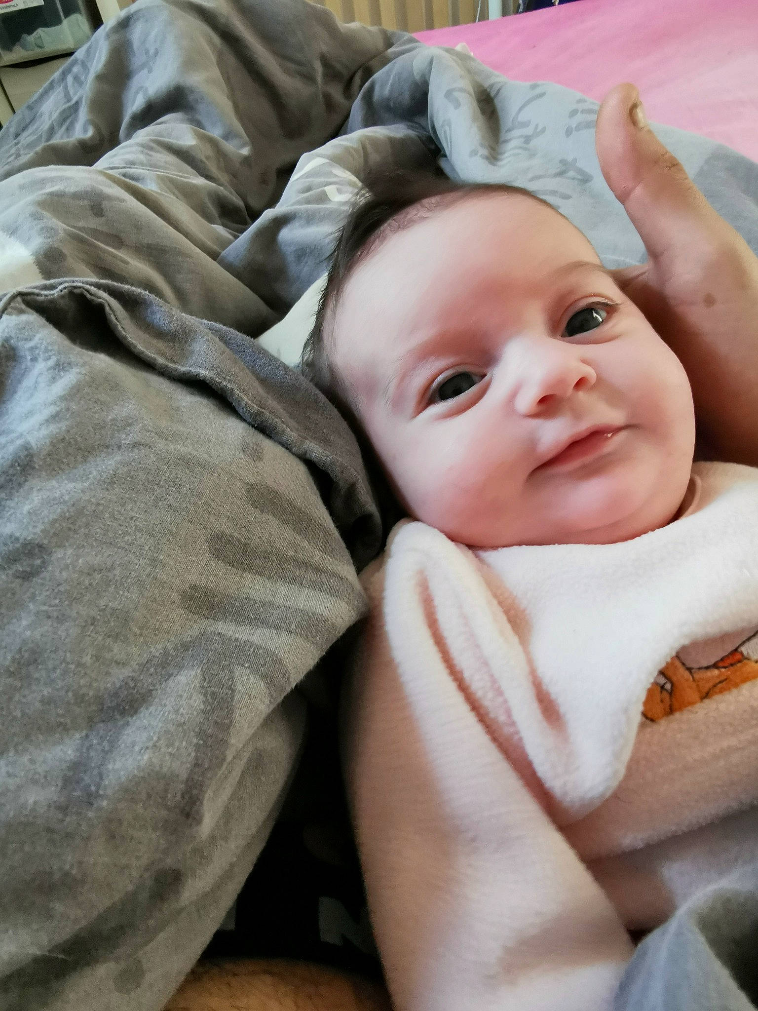 Kalya participe au concours pour gagner de l'argent avec cette photo : baby, baby_making_funny_faces, baby_products, baby_safety, baby_toddler_clothing, bedding, cheek, child, comfort, eye, grass, happy, head, linens, person, portrait_photography, room, sitting, smile, thumb