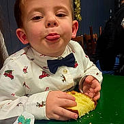 Diego a rejoint le concours — aidez-le/la à gagner de superbes lots ! child, boy, cake, food, table, napkin, bow_tie, shirt, holiday, christmas, indoor, face, tongue, playful, hands, furniture, decoration, person, celebration, smile