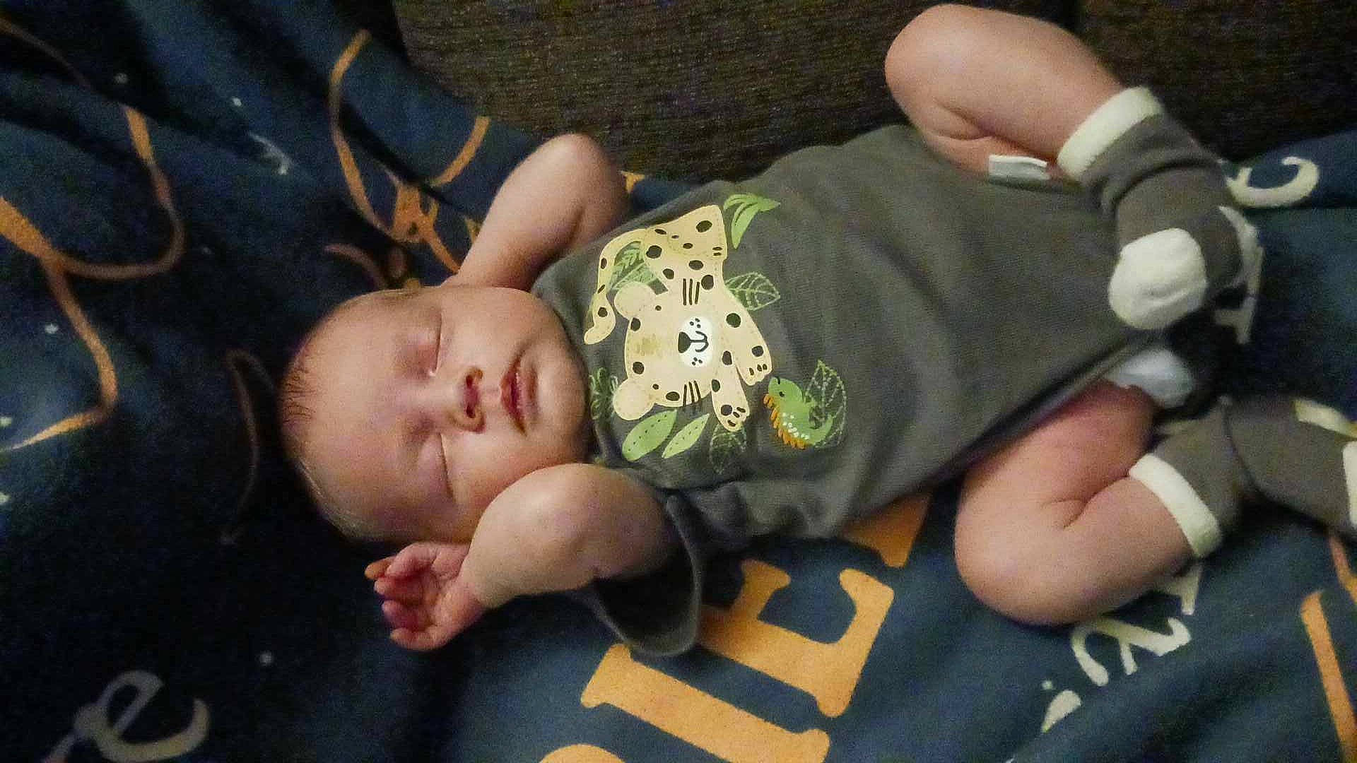 Adam is registered to the contest to win money with this photo: baby, baby_toddler_clothing, cheek, child, comfort, finger, flooring, gesture, grass, human_body, mammal, nail, pattern, person, sitting, skin, thumb, toddler, vertebrate, wood