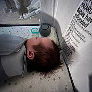 Blaise is registered to the contest to win money with this photo: baby, sleeping, crib, pacifier, star_pattern, mattress, blanket, infant, indoor, child, face, head, hair, safety_label, peaceful, resting, soft_light, closeup, person, toddler