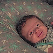 James joined the competition — help win amazing prizes! baby, bedroom, child, closeup, clothing, cute, fabric, face, happy, head, indoors, infant, pattern, person, pillow, portrait, resting, smile, soft_lighting, young