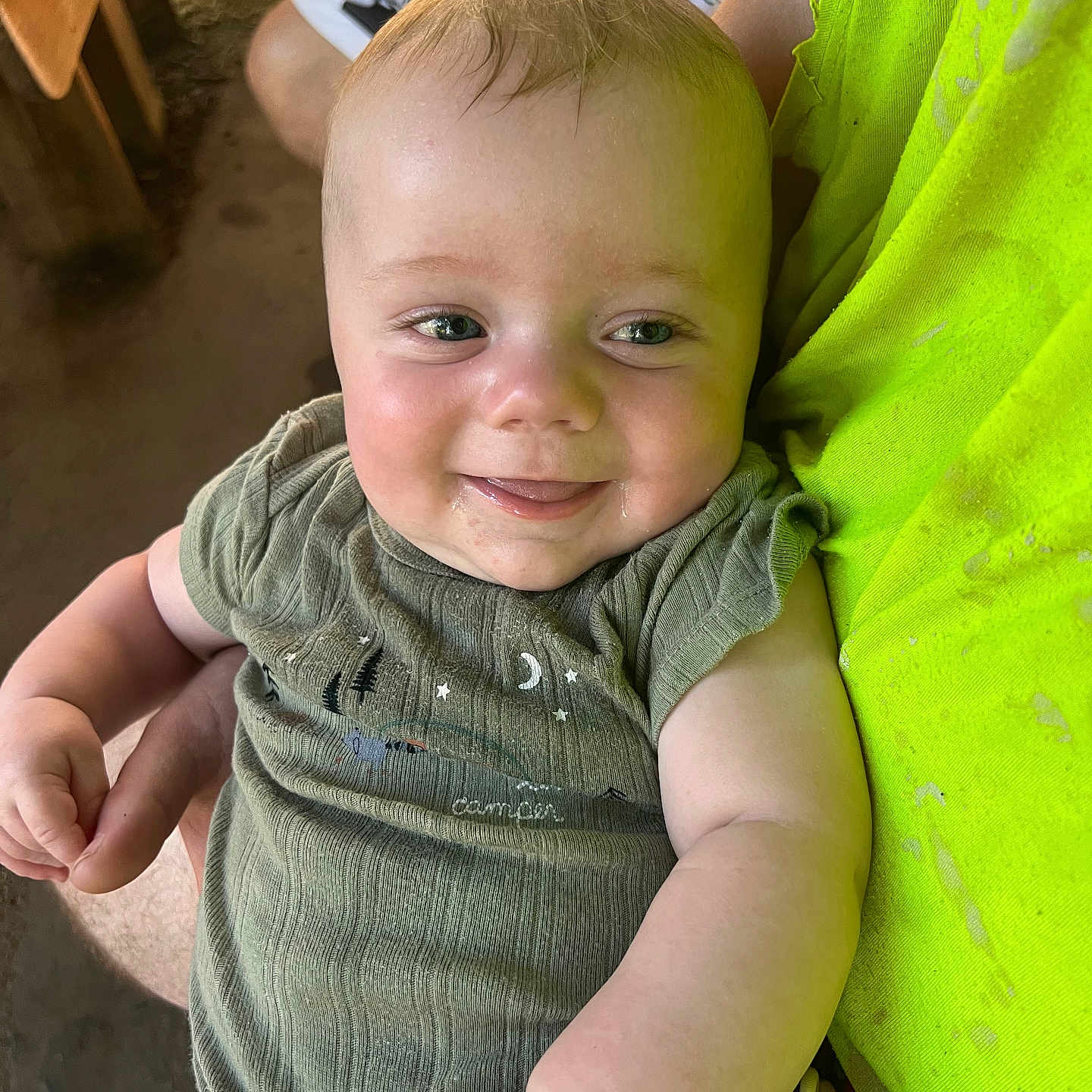 Waylon is registered to the contest to win money with this photo: arm, baby, child, closeup, cute, fabric, face, green_clothing, hand, happy, holding, indoor, infant, pacifier, person, person_holding, short_sleeves, skin, smile, toddler