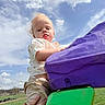 Waylon is registered to the contest to win money with this photo: child, toddler, outdoor, playground, sky, clouds, colorful, purple, green, hand, clothing, shorts, shirt, grass, daylight, fun, cute, expression, person, nature