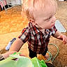 Waylon joined the competition — help win amazing prizes! toddler, child, blond_hair, curly_hair, plaid_shirt, indoor, floor, chair, barefoot, person, curious, hand, package, toy, candid, home, light, room, footwear, object