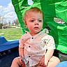 toddler, child, outdoor, playground, green_structure, blue_structure, snack, shirt, shorts, barefoot, grass, sky, clouds, daylight, sitting, curious, face, hair, person, summer
