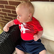 Waylon joined the competition — help win amazing prizes! baby, blue_shorts, brick_wall, casual_clothing, chair, child, curious, daylight, dinosaur_graphic, face, foot, hand, head, infant, outdoor, portrait, red_shirt, relaxed, sitting, skin
