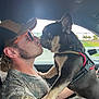 Yogi Bear is registered to the contest to win money with this photo: man, dog, french_bulldog, car_interior, cap, sunglasses, camouflage_clothing, gold_chain, dog_harness, window, greenery, side_profile, pet, animal, human, affection, cute, close_up, interaction, transportation