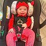 baby, child, car_seat, elf_costume, red_clothing, striped_pants, smiling, happy, festive, holiday, infant, seatbelt, indoors, cute, hat, green_clothing, footwear, person, portrait, young