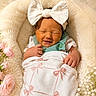newborn, baby, smiling, blanket, bow_headband, flowers, pink_bows, cozy, soft, cute, infant, wrapped, resting, peaceful, portrait, closeup, baby_clothing, floral, headwear, sleepy
