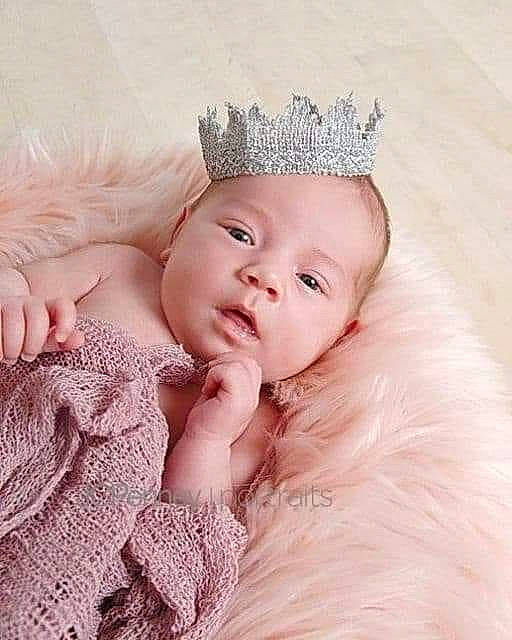 Taylynn is registered to the contest to win money with this photo: baby, cheek, child, child_model, crown, eye, face, forehead, hair_accessory, head, headgear, headpiece, iris, lip, nose, person, photograph, photography, pink, skin