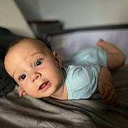 Sacha a rejoint le concours — aidez-le/la à gagner de superbes lots ! baby, infant, child, face, eyes, mouth, skin, head, light_blue_clothing, bed, blanket, soft, indoors, portrait, lying_down, expression, curious, cute, human, young