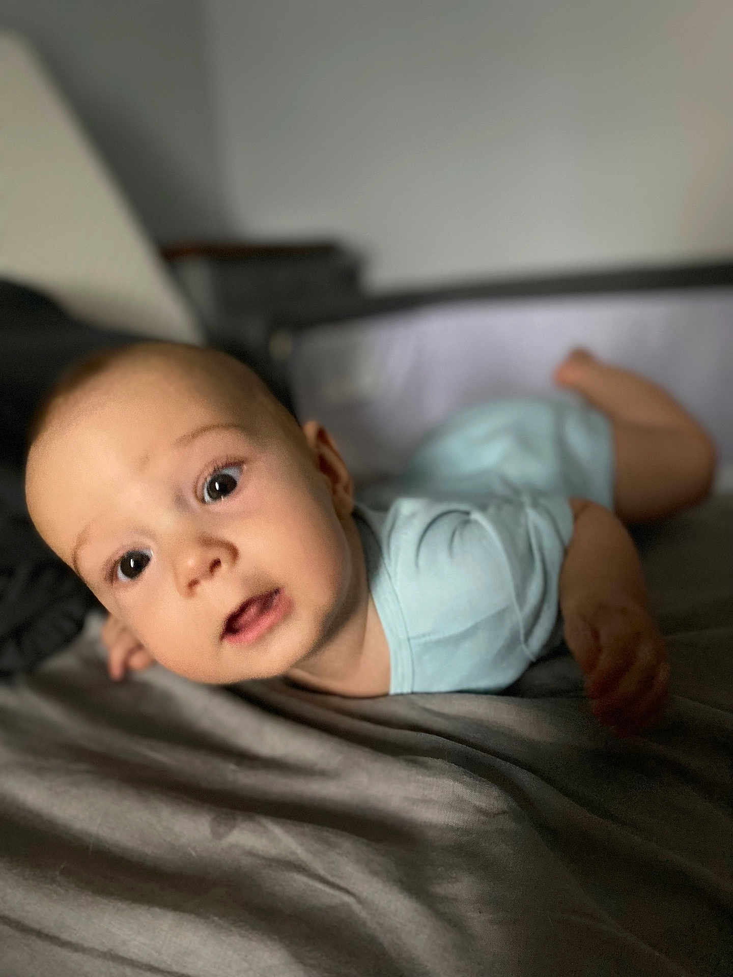Sacha a rejoint le concours — aidez-le/la à gagner de superbes lots ! baby, infant, child, face, eyes, mouth, skin, head, light_blue_clothing, bed, blanket, soft, indoors, portrait, lying_down, expression, curious, cute, human, young