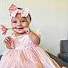 baby, child, pink_dress, headband, bow, flower, smile, happy, cute, indoors, portrait, hand, pearl_necklace, person, infant, celebration, fashion, toddler, adorable, playful
