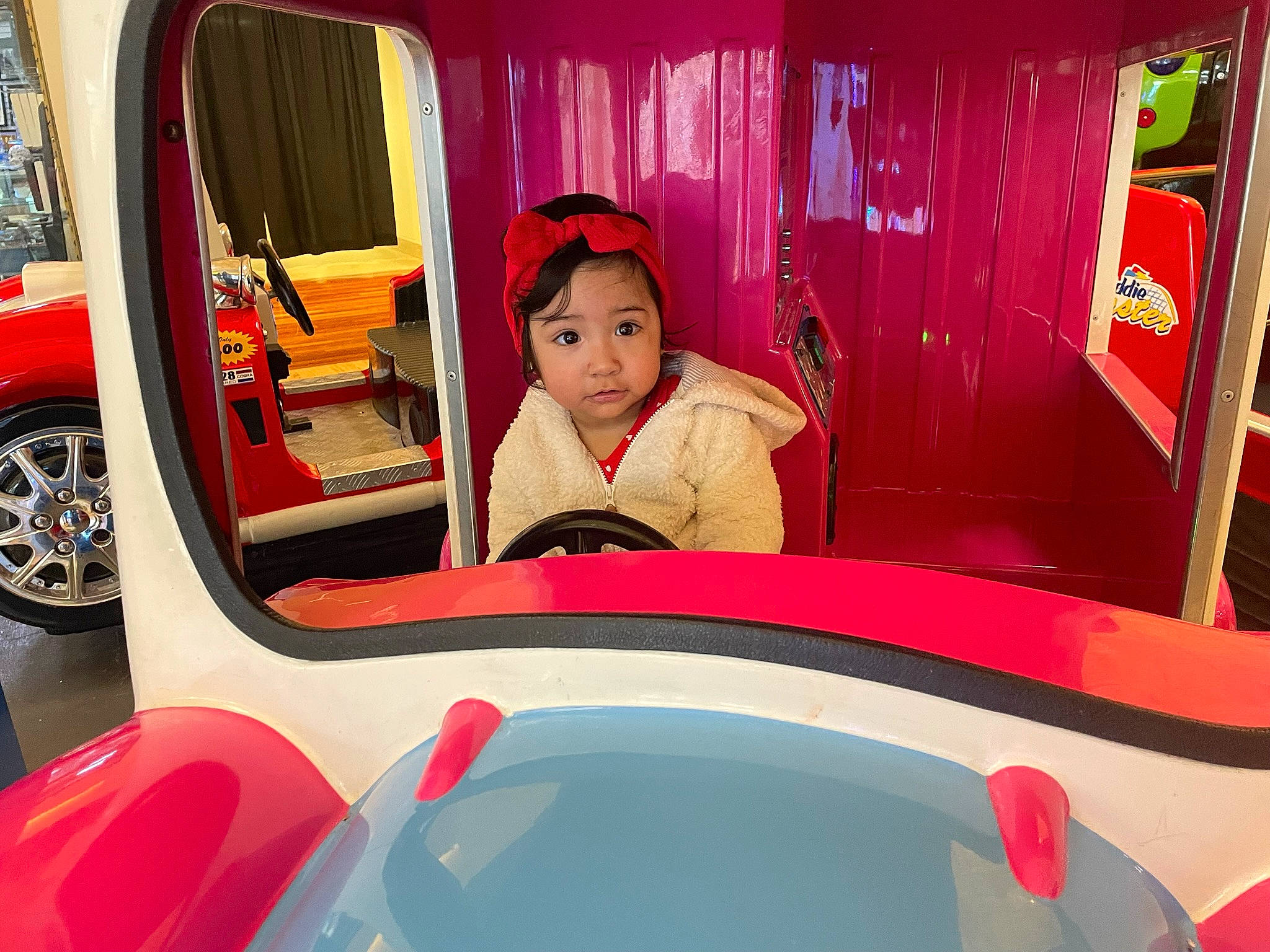 Kehlani is registered to the contest to win money with this photo: automotive_design, automotive_exterior, bumper, car, child, classic, curtain, fun, leisure, magenta, motor_vehicle, person, pink, playground, recreation, red, tire, toddler, vehicle, vehicle_door