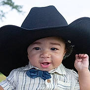 Waylon is registered to the contest to win money with this photo: accessories, baby, bonnet, cap, clothing, cowboyhat, face, formalwear, hat, head, person, photography, portrait, sombrero, sunhat, tie