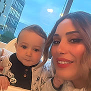 Joulene participe au concours pour gagner de l'argent avec cette photo : baby, woman, smiling, high_chair, indoor, window, building, blue_sky, face, portrait, happy, child, clothing, person, seated, hair, eyebrows, makeup, skin, casual