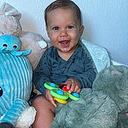 Luis participe au concours pour gagner de l'argent avec cette photo : baby, smiling, child, toy, stuffed_animal, plush, blue_wall, happy, face, indoor, clothing, hand, sitting, baby_toy, cute, infant, playful, portrait, young_child, soft_toy