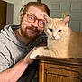 Princess joined the competition — help win amazing prizes! affection, beard, casual_clothing, cat, closeup, cream_cat, door, furniture, glasses, hello_fall, hoodie, indoor, man, pet, portrait, red_hair, relaxing, seasonal_decor, warm_lighting, wooden_cabinet