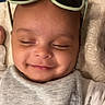 Ibrahim joined the competition — help win amazing prizes! baby, smiling, closed_eyes, sunglasses, bib, blanket, infant, face, cute, sleepy, cozy, apparel, child, portrait, resting, headwear, soft_texture, indoors, young, relaxed