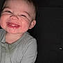 Bennett is registered to the contest to win money with this photo: baby, child, smiling, face, onesie, happy, indoor, dark_background, portrait, person, infant, cute, expression, young, head, skin, mouth, teeth, hair, clothing