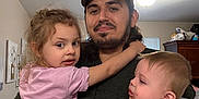 Amelia is registered to the contest to win money with this photo: child, baby, man, family, indoor, holding, parent, father, casual, clothing, love, affection, portrait, home, smile, curly_hair, watch, tattoo, cap, window