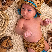 Kaylen is registered to the contest to win money with this photo: newborn, baby, child, infant, portrait, lying_down, crocheted_hat, costume, brown, blanket, teddy_bear, rocking_horse, nursery, cozy, indoor, plant, wooden_toy, hand, bare_skin, photography