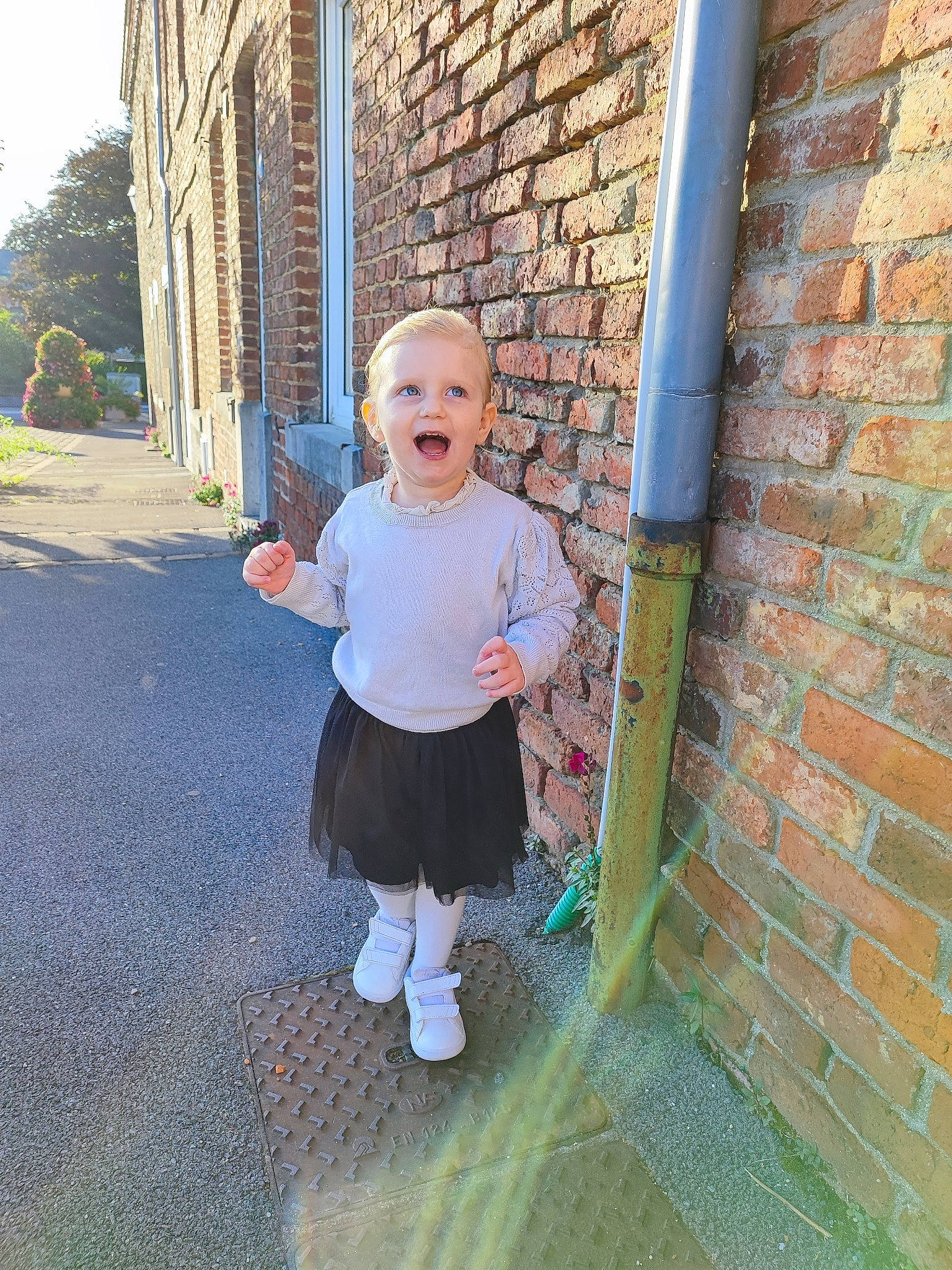 émy participe au concours pour gagner de l'argent avec cette photo : baby_toddler_clothing, brick, brickwork, building, child, electric_blue, fun, grass, hairstyle, leisure, pattern, person, plant, recreation, sidewalk, sleeve, stairs, toddler, tree, vacation