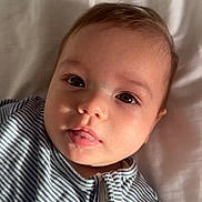 Jaziya joined the competition — help win amazing prizes! baby, child, face, portrait, striped_clothing, infant, cute, lying_down, soft_light, expression, young, human, skin, eyes, mouth, zipper, blanket, indoors, closeup, person