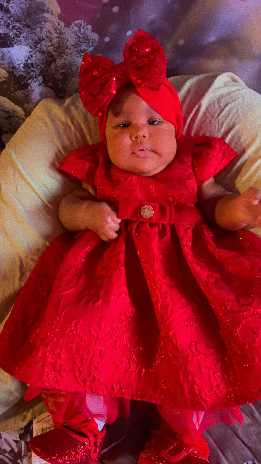 Ava joined the competition — help win amazing prizes! baby, red_dress, headband, bow, shoes, glitter, infant, child, portrait, cute, indoors, fabric, pattern, clothing, sitting, person, face, cute_expression, holiday, soft_background