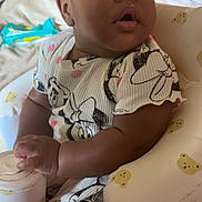 Ava is registered to the contest to win money with this photo: baby, infant, child, cute, face, arm, hand, sitting, clothing, indoor, furniture, inflatable_chair, pattern, bear, curious, expression, skin, portrait, young, person