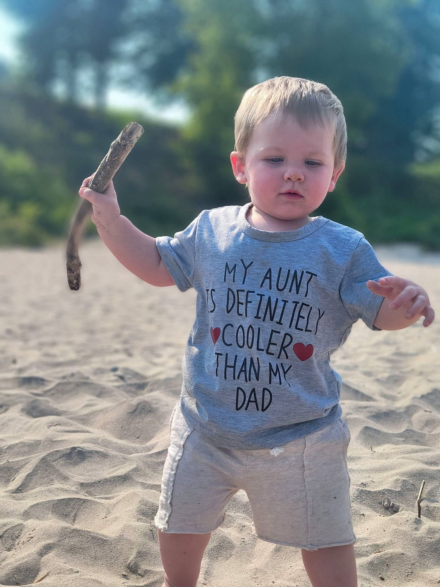 Sylus is registered to the contest to win money with this photo: arm, baby_toddler_clothing, beach, beauty, fun, gesture, happy, joint, leisure, natural_environment, people_in_nature, people_on_beach, person, sand, shoulder, sleeve, standing, summer, t_shirt, toddler