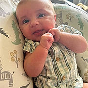 Lowen is registered to the contest to win money with this photo: baby, infant, child, plaid_clothing, cushion, animal_print, face, hands, blue_eyes, indoor, cute, portrait, sitting, soft_light, buttoned_shirt, newborn, skin, expression, comfort, young