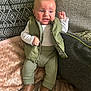 Lowen joined the competition — help win amazing prizes! baby, child, infant, clothing, vest, pants, shoes, couch, pillow, blanket, texture, curious, expression, indoor, person, seated, footwear, green, brown, comfortable