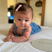 Valentine a rejoint le concours — aidez-le/la à gagner de superbes lots ! baby, pink_bow, blue_eyes, baby_clothing, bed, white_bedspread, indoor, portrait, child, cute, infant, hands, face, skin, hair, room, blurred_background, curious_expression, lying_down, soft_lighting