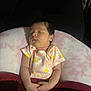 Scarlett joined the competition — help win amazing prizes! baby, sleeping, infant, onesie, daisy_pattern, cushion, blanket, hands, face, peaceful, resting, soft, pink, red, dark_background, indoors, child, newborn, portrait, comfort