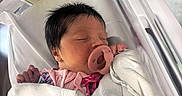 Scarlett is registered to the contest to win money with this photo: baby, bassinet, blanket, child, clothing, cute, face, hospital, hospital_bed, indoors, infant, newborn, pacifier, peaceful, person, pillow, pink, sleeping, white, wrapped