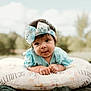 Scarlett joined the competition — help win amazing prizes! baby, child, clothing, cute, daylight, expression, face, grass, hands, head, headband, infant, lying_down, nature, outdoor, pillow, portrait, smile, soft_fabric, young_child
